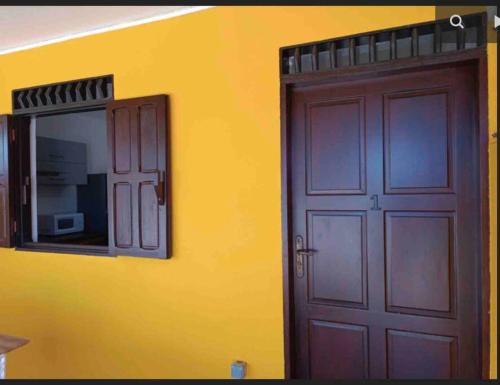 a door with a mirror next to a yellow wall at Mana - SRFB 3 in Mana