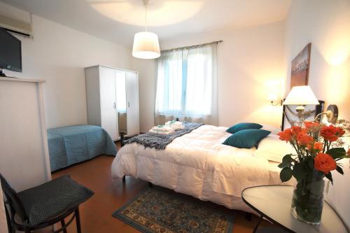 Un dormitorio con una cama y una mesa con un jarrón de flores en Posto Nove Country House, en Corropoli