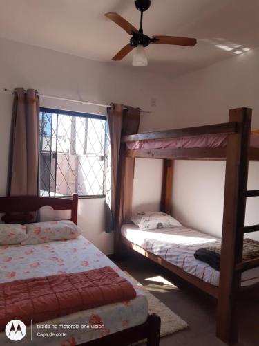 een slaapkamer met 2 stapelbedden en een plafondventilator bij Casa de Praia em Barra Velha Itajuba SC por Temporada in Barra Velha