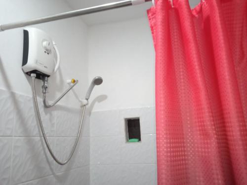 a shower with a red shower curtain in a bathroom at Sarah's Garden BnB & Spa in Clarin