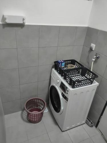 a washing machine in a bathroom with a basket at Infinity pool apartment with stunning sunset view - GM Remia Residence Ambang Botanic in Klang