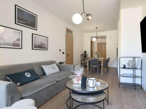 un salon avec un canapé et une table dans l'établissement Appartement moderne 46 m², 4 pers, Courchevel Moriond, skis aux pieds, balcon, parking, wifi, ascenseur - FR-1-631-170, à Courchevel