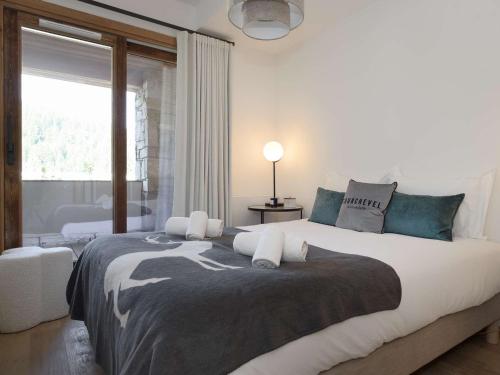 une chambre avec un grand lit avec une grande fenêtre dans l'établissement Appartement moderne 46 m², 4 pers, Courchevel Moriond, skis aux pieds, balcon, parking, wifi, ascenseur - FR-1-631-170, à Courchevel