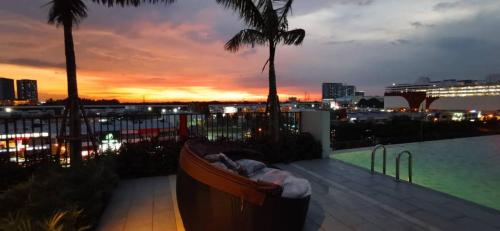 a view of a city from a balcony at sunset at Infinity pool apartment with stunning sunset view - GM Remia Residence Ambang Botanic in Klang