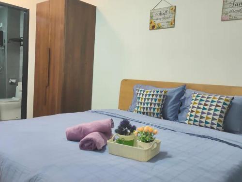 a bed with a bowl of fruit and flowers on it at Infinity pool apartment with stunning sunset view - GM Remia Residence Ambang Botanic in Klang