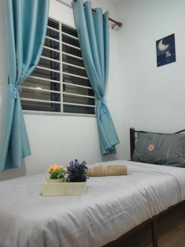 a bedroom with a bed with blue curtains and a window at Infinity pool apartment with stunning sunset view - GM Remia Residence Ambang Botanic in Klang