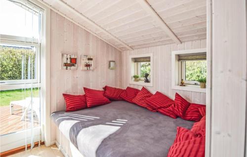 SønderbyにあるNice Home In Juelsminde With Saunaの赤い枕付きの大きなベッドが備わる客室です。