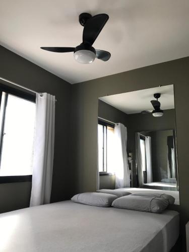 een slaapkamer met een bed en een plafondventilator bij Confortável, Equipado e Bem Localizado c/ Garagem in Curitiba