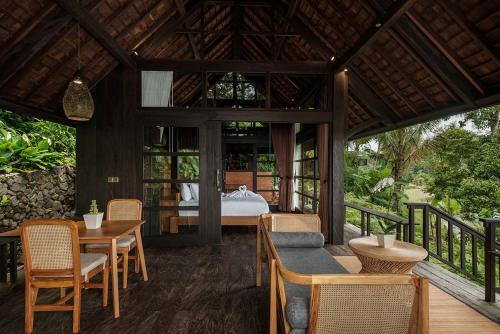 een kamer met een bed en een tafel en stoelen bij Villa Togog in Penebel
