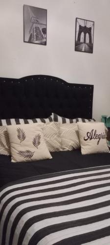 a black and white bed with pillows on it at La familia in Ezeiza