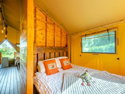 um quarto numa tenda com uma cama com almofadas laranja em The Foxes Den - Uk45295 em Bishop Thornton