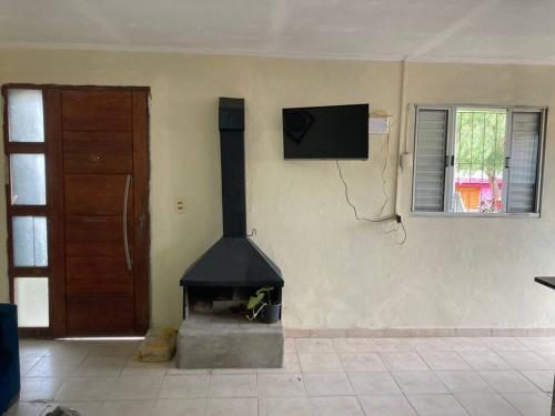 chimenea en una habitación con puerta y TV en Casa centrica!, en Artigas