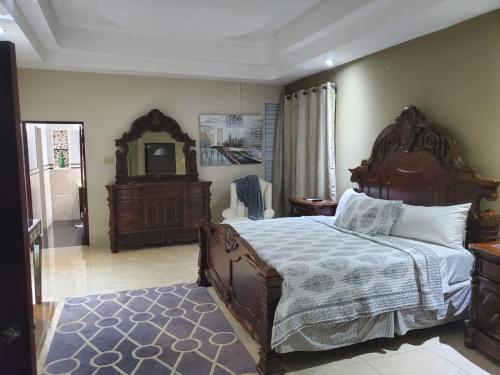 1 dormitorio con 1 cama grande y espejo en The Palms- Caribbean Estates -10 minutes from the beach- Gated Community, en Portmore