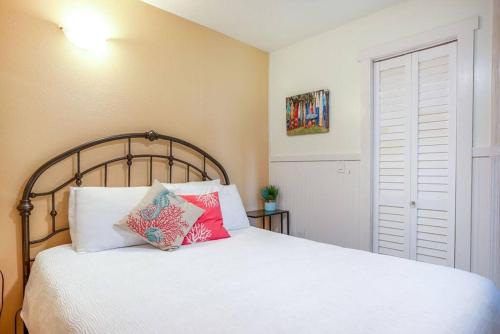 a bedroom with a white bed with pillows on it at Pahoa Tropical Garden Getaway in Pahoa