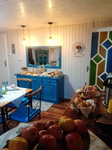 une cuisine avec des placards bleus et une table avec des fruits dans l'établissement Pousada Vivenda das Flores Ltda, à Bom Jardim da Serra