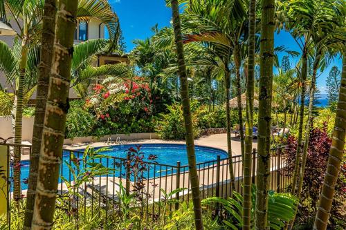 a pool in the middle of a garden with palm trees at Kapalua Golf Villas 15P5-6 condo in Kahana