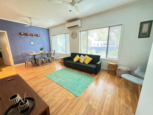 a living room with a black couch and a table at Pete's Place in Berrimah