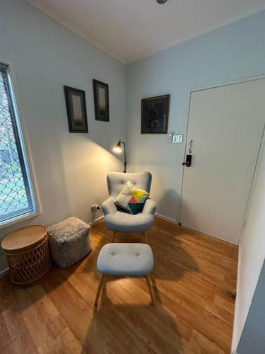 a living room with a chair and a stool at Pete's Place in Berrimah