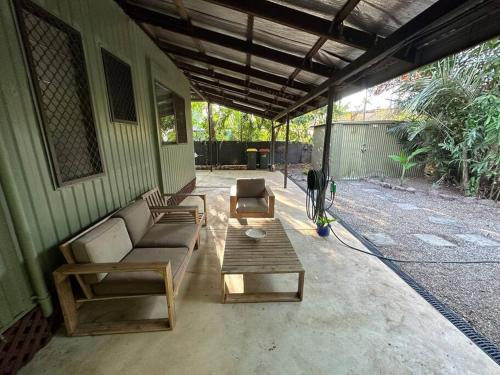 a patio with couches and a table on a house at Pete's Place in Berrimah