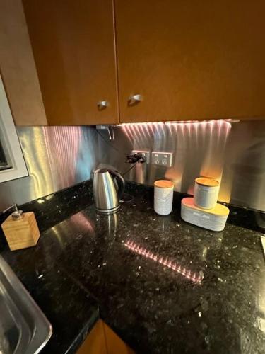 a kitchen with a black counter top with two candles at Pete's Place in Berrimah