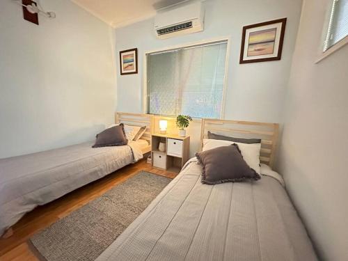 a bedroom with two beds and a window at Pete's Place in Berrimah