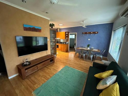 a living room with a couch and a large flat screen tv at Pete's Place in Berrimah