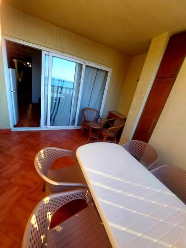 Habitación con mesa, sillas y balcón. en Chalet in Porto Marina North Coast, en El Alamein