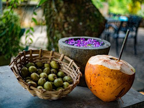 a basket of fruit sitting next to a basket of nuts at Singharaja Garden AGRO ECO Lodge in Pelawatta
