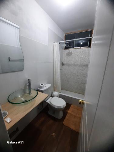 a bathroom with a toilet and a sink and a shower at Wayra Hospedaje in Cajamarca