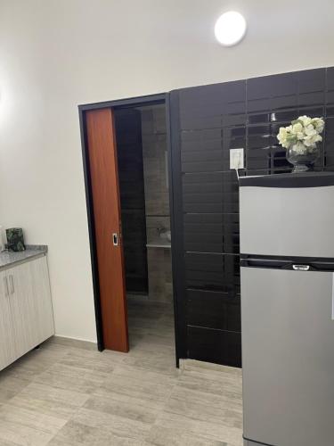 eine Küche mit einem Kühlschrank und einer schwarzen Wand in der Unterkunft Espectacular Departamento moderno ,acogedor en vicente López in Vicente López