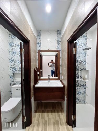 a man taking a picture of a bathroom with a sink at Namkhan Riverside Hotel in Luang Prabang