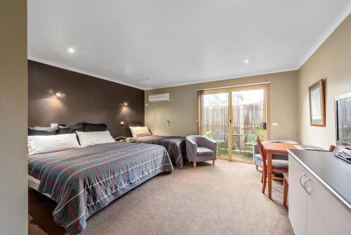 a hotel room with two beds and a balcony at Motel Strahan in Strahan