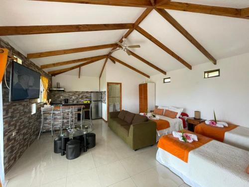 a room with two beds and a couch and a kitchen at Mata ki te Rangi Rapa Nui in Hanga Roa