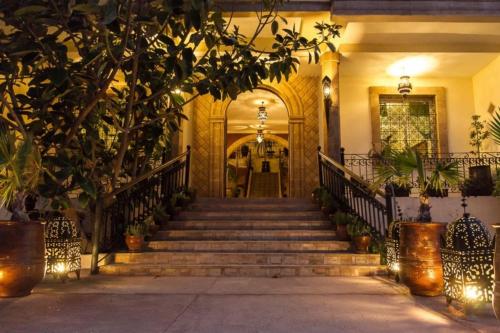 an entrance to a house with stairs and trees at Riad Zahra in Essaouira