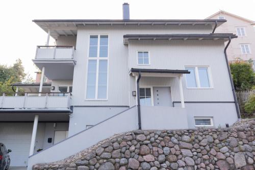 a house with a stone wall in front of it at Villa Rajaportti 1st&2nd floor Loft with lakeview and free front door parking with electric car plug in Tampere