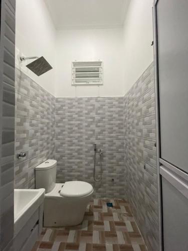 uma casa de banho com um WC, um lavatório e um chuveiro em Dhuha & Dharyl's Staycation em Kota Bharu