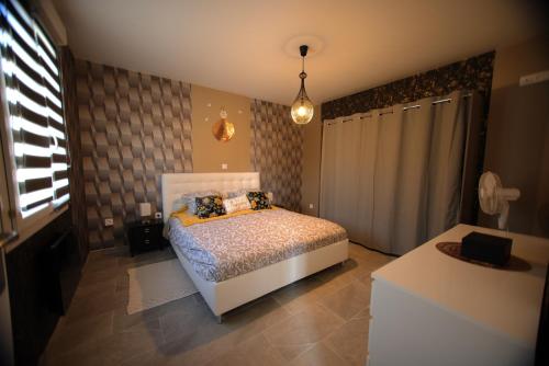 um quarto com uma cama no canto de um quarto em Magnifique Maison de plain-pied Neuf 