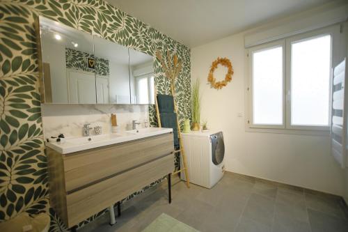 uma casa de banho com um lavatório e um espelho grande em Magnifique Maison de plain-pied Neuf 