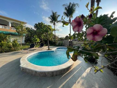 a swimming pool in a yard with flowers at Villa Hermosa1 / Piscina in San Felipe de Puerto Plata
