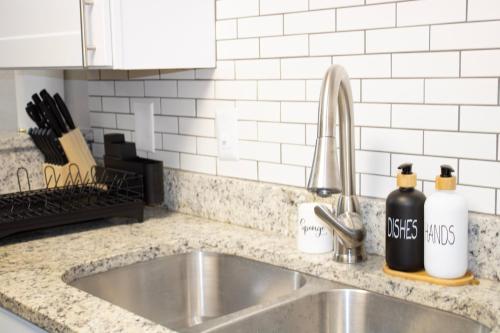 a kitchen sink with two bottles on a counter at Walk to AT&T Stadium , Globelife from Cozy 2bd/ba Apartment in Arlington