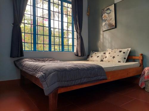 a bed sitting in a room with a window at The Lazy Farm-Garden Central Room in Mewal
