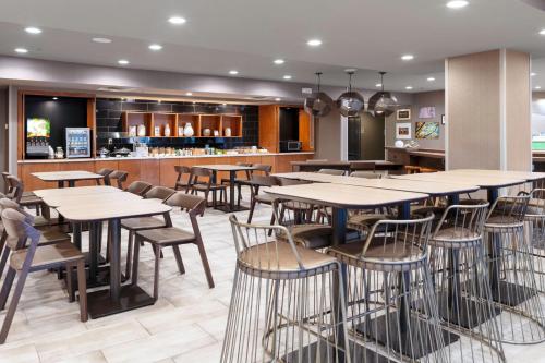 a restaurant with tables and chairs and a bar at SpringHill Suites by Marriott Baton Rouge South in Baton Rouge