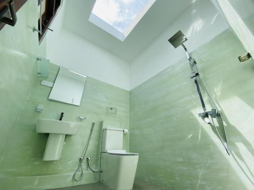 ein Bad mit einer Dusche, einem WC und einem Waschbecken in der Unterkunft La Seran Eco Resort in Bandarawela