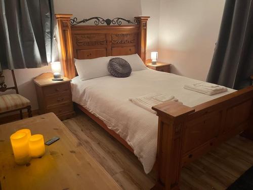 a bedroom with a large bed with two candles on a table at Bushtown Lodge in Macosquin