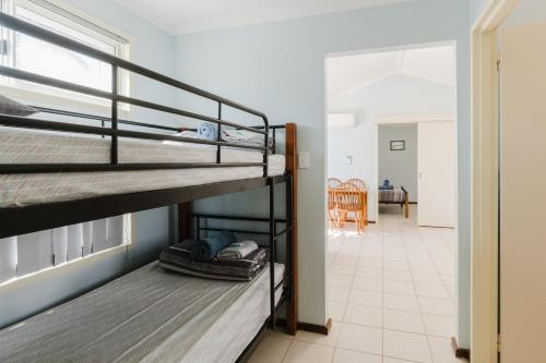 a room with two bunk beds and a hallway at Peoples Park in Coral Bay