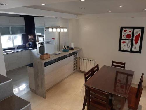 uma grande cozinha com uma mesa e um frigorífico em Moderno Duplex - Alquiler en Comodoro Rivadavia em Comodoro Rivadavia