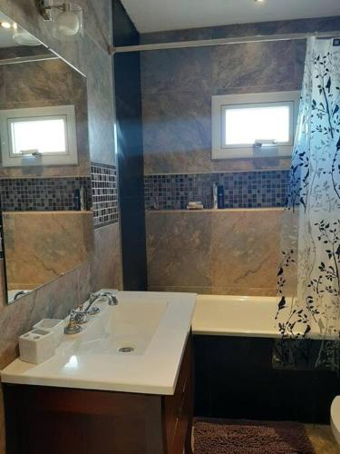 a bathroom with a sink and a shower curtain at Moderno Duplex 2 - Alquiler en Comodoro Rivadavia in Comodoro Rivadavia