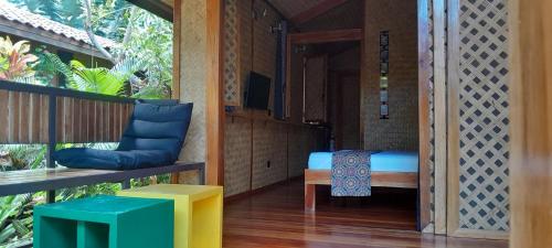Zimmer mit einem Bett und einer Bank auf einer Veranda in der Unterkunft At Home in Puerto Princesa