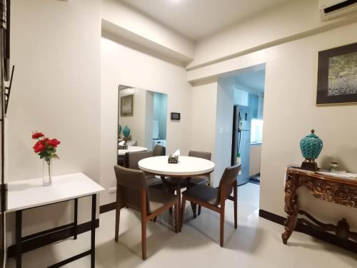 a dining room with a table and chairs and a mirror at Mactan Newtown Cebu Affordable Suite! in Mactan