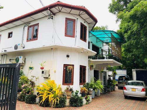 een wit huis met een auto ervoor geparkeerd bij St Anne's Hotel & Restaurant in Jaffna